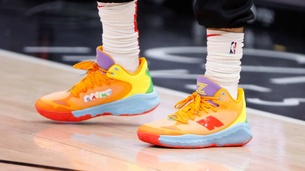View of orange and purple New Balance shoes.